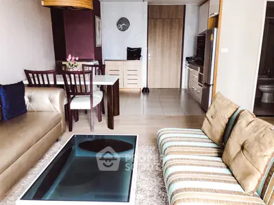 Stylish living room with modern furniture and open kitchen layout in a contemporary apartment.