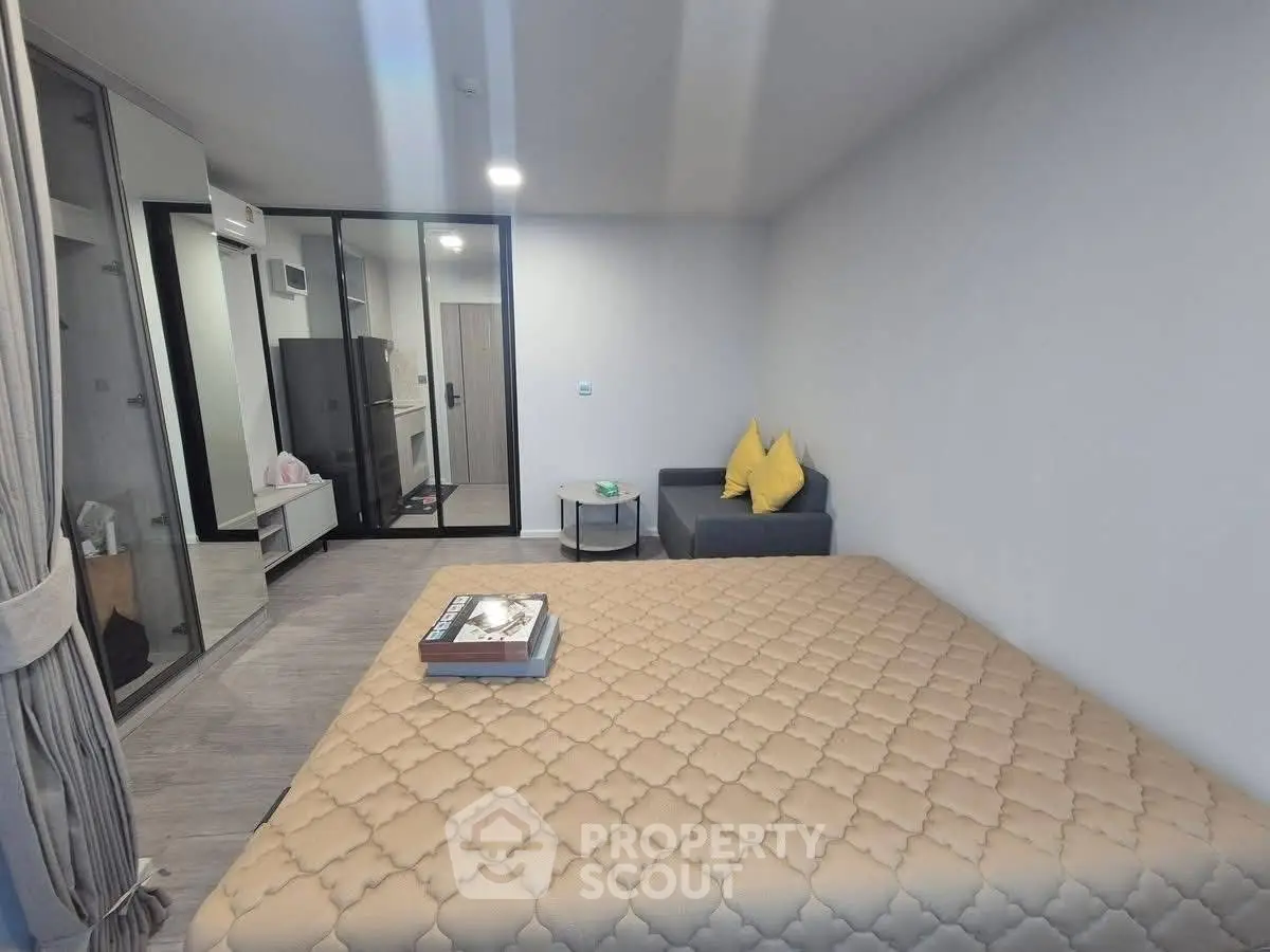 Modern bedroom with cozy sofa and stylish decor in a contemporary apartment.