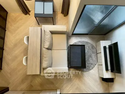 Modern living room with cozy sofa, TV setup, and stylish dining area in compact space.