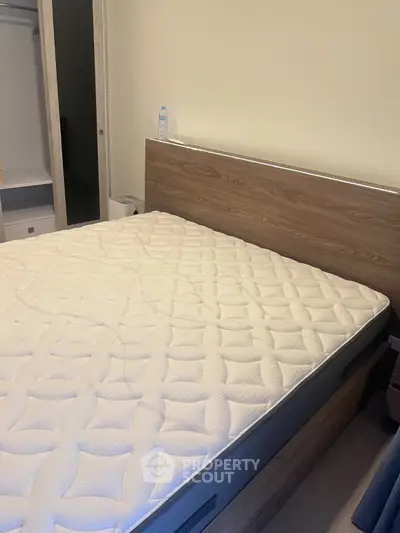 Spacious bedroom with modern wooden bed frame and comfortable mattress, ideal for restful nights.
