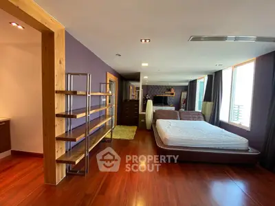 Spacious bedroom with wooden flooring and modern decor in luxury apartment