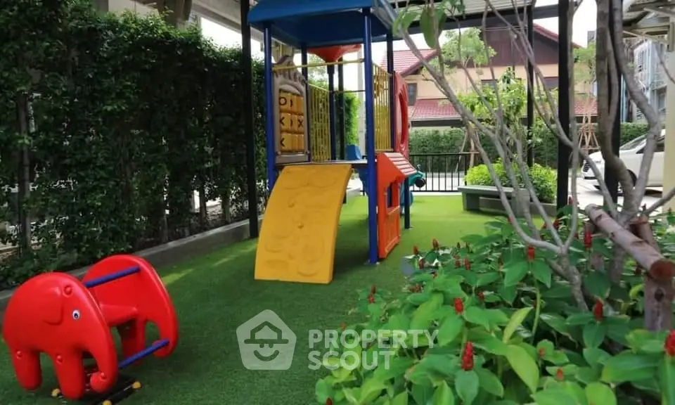 Charming outdoor playground area with vibrant play equipment and lush greenery, perfect for family-friendly living.