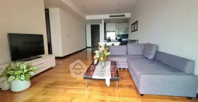 Spacious modern living room with sleek furniture and open kitchen layout.