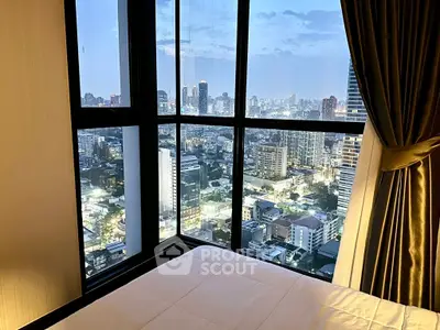 Luxurious bedroom with stunning city view from floor-to-ceiling windows.