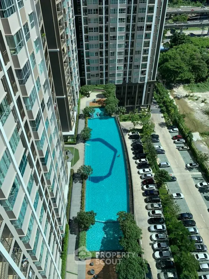 Stunning aerial view of modern high-rise buildings with a luxurious swimming pool and lush greenery.