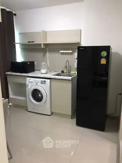 Modern laundry room with washing machine and sleek cabinetry.