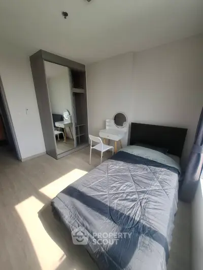Modern bedroom with sleek design, featuring a single bed, mirrored wardrobe, and stylish vanity desk.