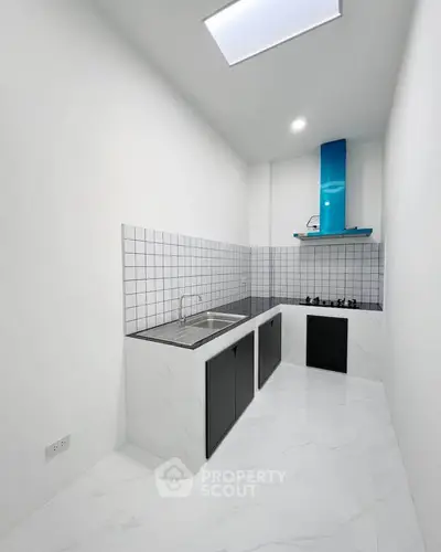 Modern minimalist kitchen with sleek black cabinets and gas stove