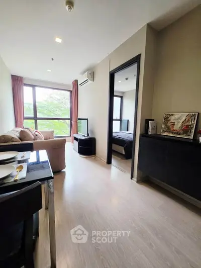Modern living room with large window and cozy seating in a stylish apartment