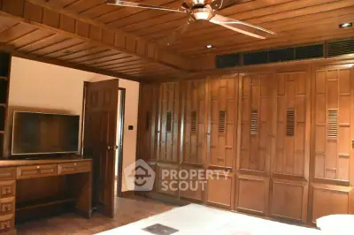 Spacious bedroom with wooden built-in wardrobes and ceiling fan