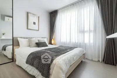 Modern bedroom with stylish decor and natural light, featuring cozy bedding and elegant curtains.