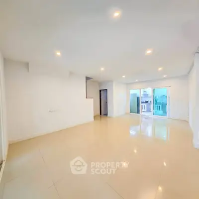 Spacious modern living room with glossy tiled floors and bright lighting, ideal for family gatherings.