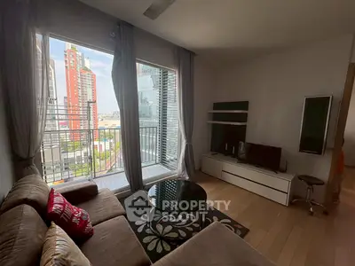 Modern living room with large window and city view, featuring cozy sofa and entertainment unit.