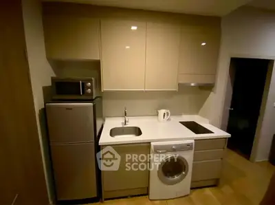 Modern compact kitchen with integrated appliances and sleek cabinetry