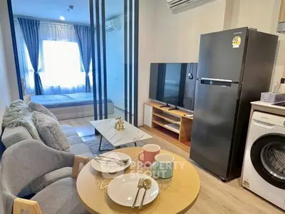 Modern studio apartment with open layout, featuring cozy living area and stylish kitchen appliances.