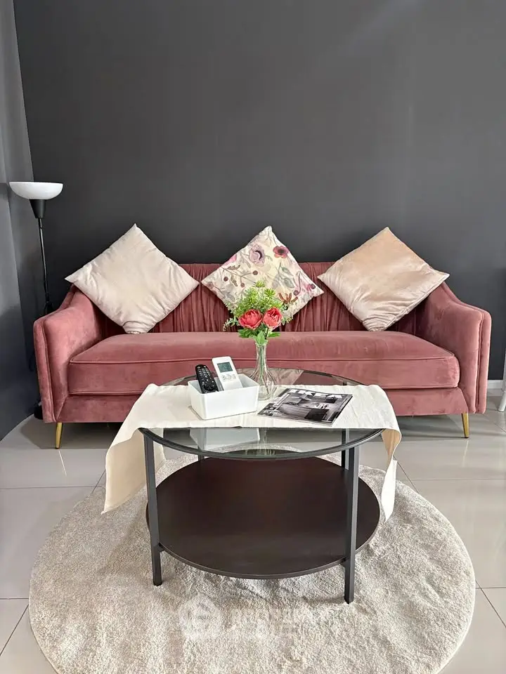 Stylish living room with pink velvet sofa, elegant decor, and modern glass coffee table.