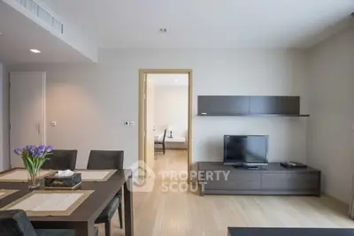 Modern living room with dining area and TV setup, featuring sleek furniture and neutral tones.