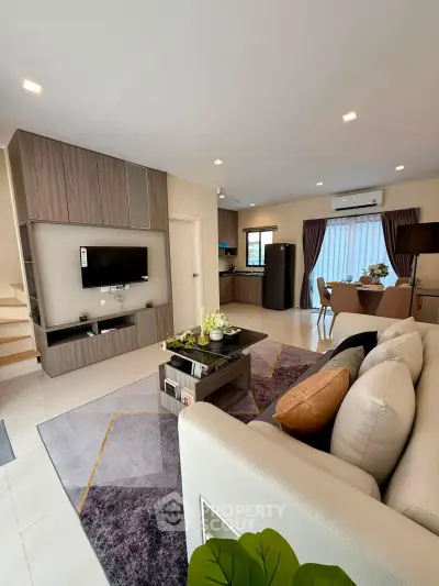 Modern open-plan living room with stylish decor and integrated kitchen area, perfect for contemporary living.