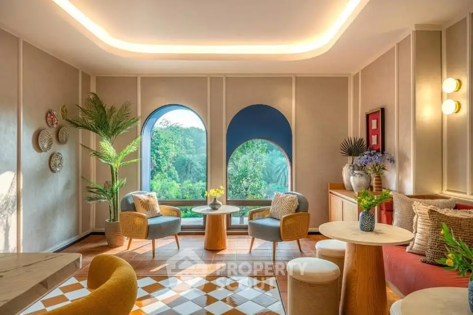 Charming living room with arched windows and stylish decor overlooking lush greenery.