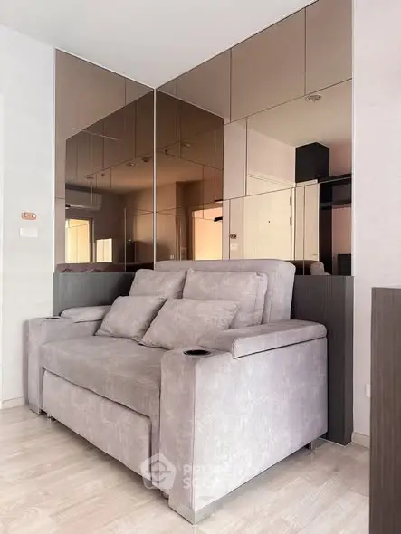 Modern living room with stylish sofa and mirrored wall panels