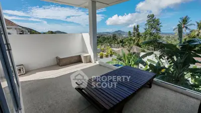 Spacious balcony with stunning panoramic views of lush greenery and distant mountains.