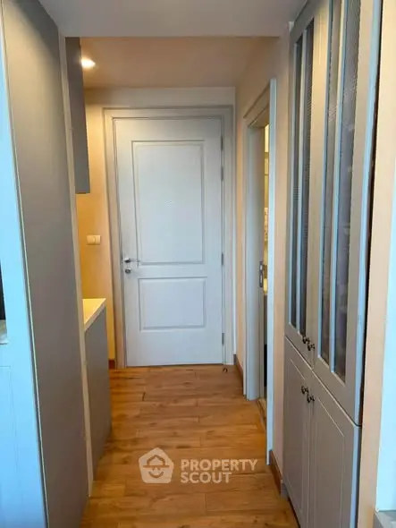 Charming hallway with wooden flooring and elegant cabinetry in modern apartment.