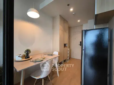 Modern kitchen with sleek design, featuring a dining table and contemporary lighting.