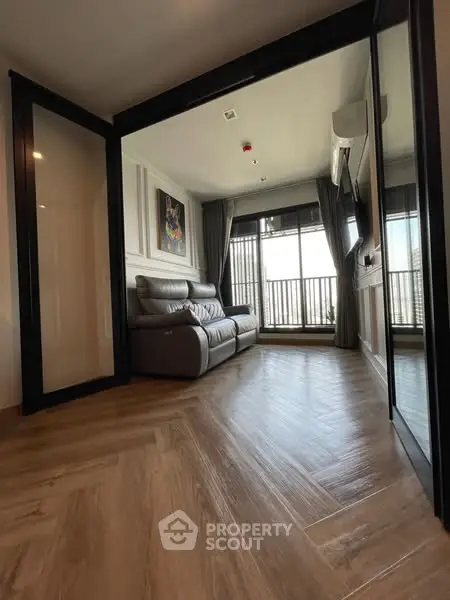 Modern living room with sleek wooden flooring and balcony view