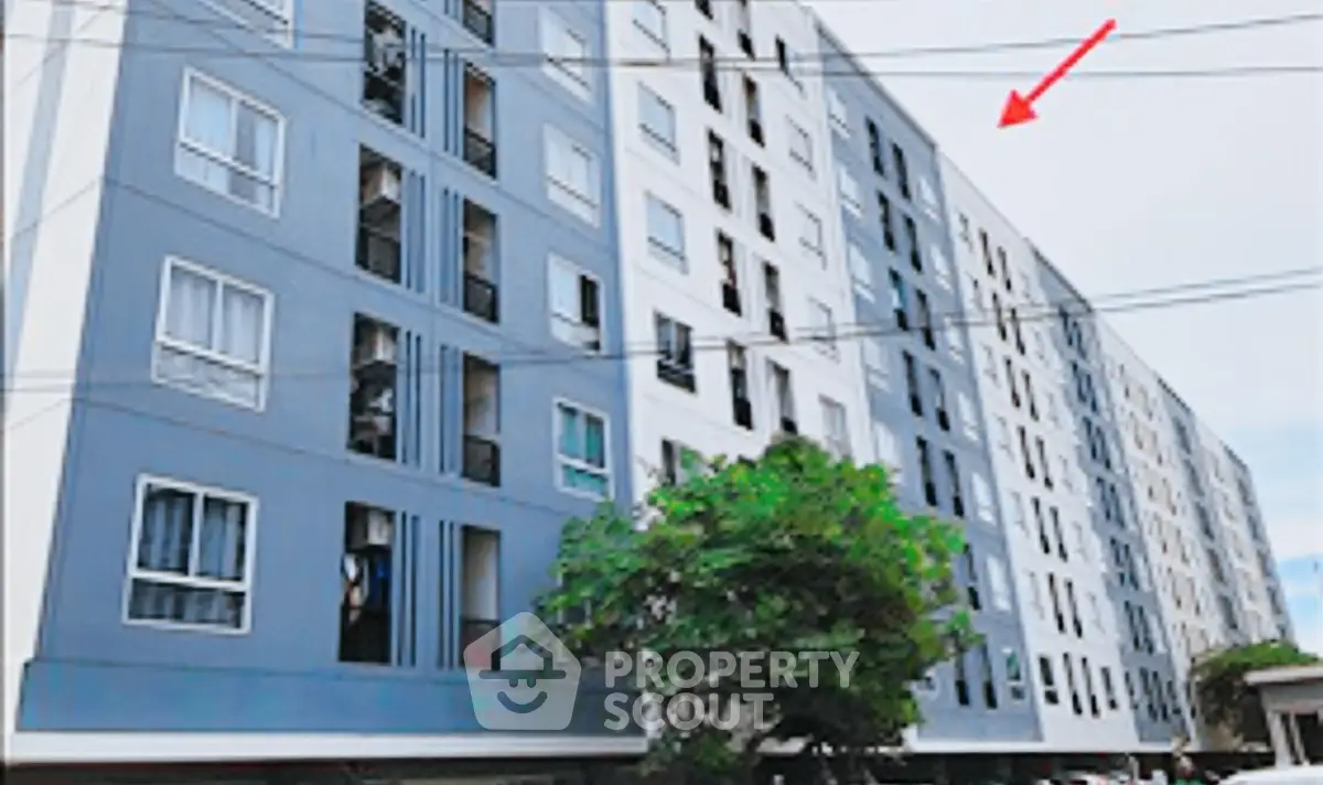 Modern multi-story residential building with sleek facade and large windows.