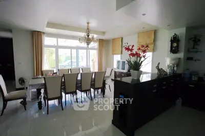 Elegant dining room with chandelier and large windows in a modern home.