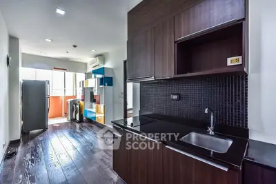 Modern kitchen with sleek dark cabinets and open layout in a stylish apartment