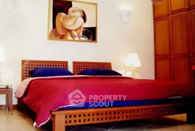 Elegant bedroom with modern art, cozy lighting, and wooden furniture for a warm ambiance.