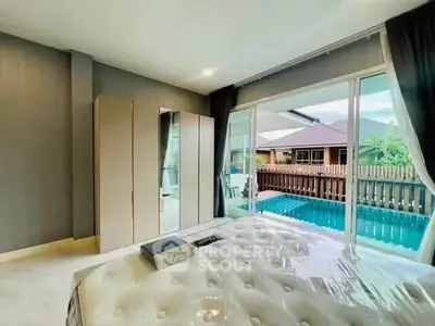 Luxurious bedroom with pool view and modern decor, perfect for relaxation and comfort.