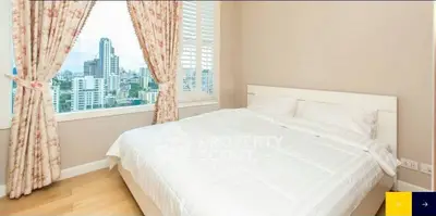 Bright bedroom with city view and floral curtains in modern apartment