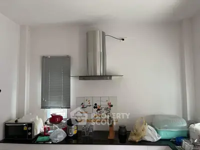 Modern kitchen with stainless steel range hood and playful tile backsplash