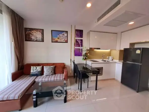 Modern open-layout living room and kitchen with stylish decor and natural light.