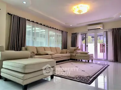 Spacious living room with elegant beige furniture and large windows for natural light.