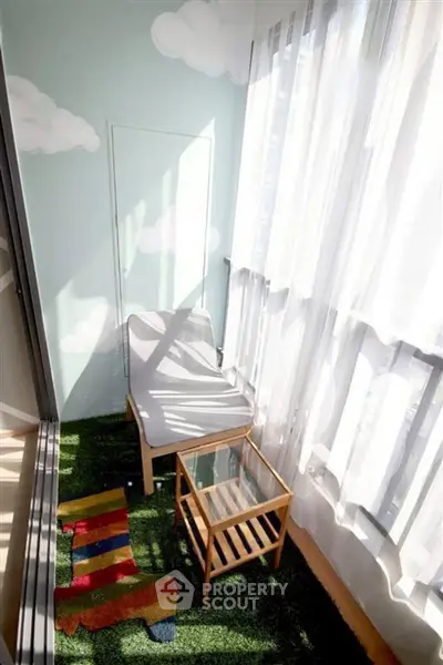 Charming balcony with cozy seating and glass table, perfect for relaxation.