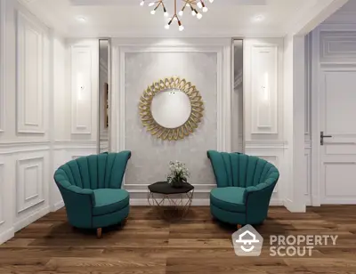 Elegant living room with plush teal armchairs, classic white wainscoting, and a striking sunburst mirror creating a luxurious and inviting space.