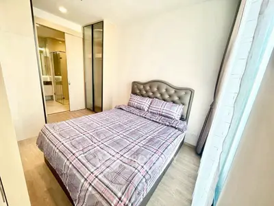 Cozy bedroom with modern design and ensuite bathroom in a bright apartment.
