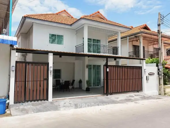 Charming two-story house with tiled roof and spacious driveway in a serene neighborhood.