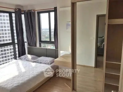 Modern bedroom with large windows and city view in high-rise apartment