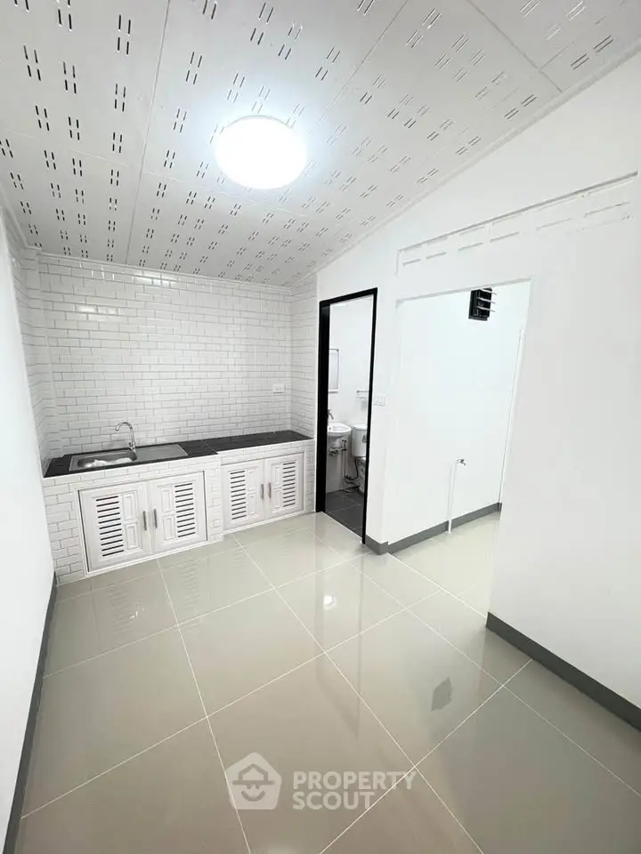 Modern minimalist kitchen with sleek white cabinetry and tiled backsplash