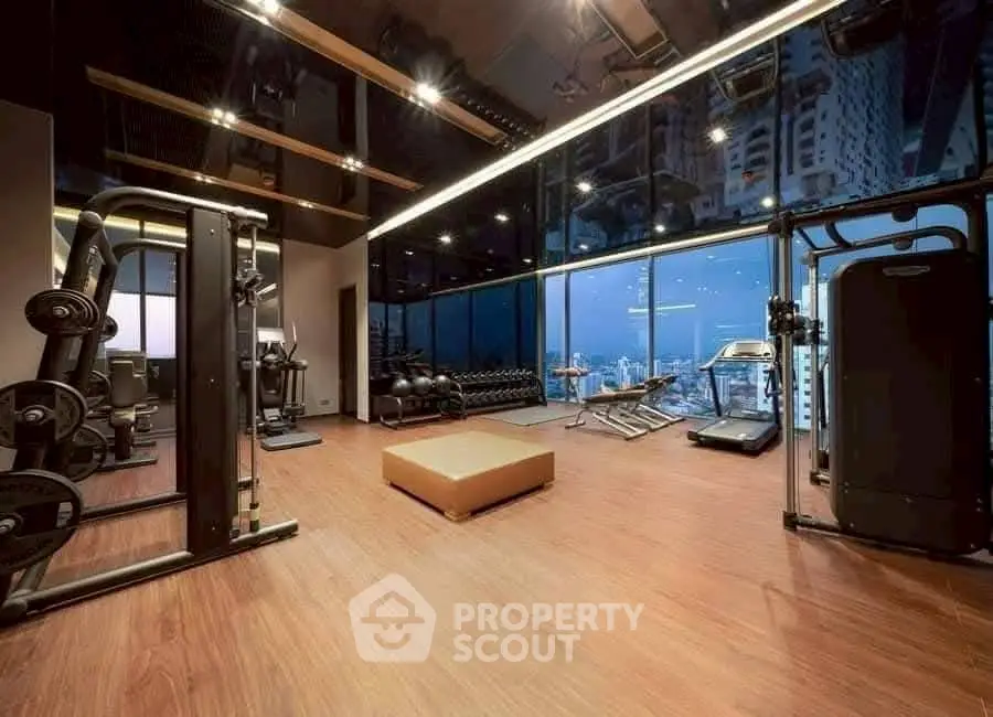 Luxurious high-rise gym with stunning city skyline view and modern equipment.