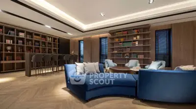 Luxurious living room with elegant blue sofas and built-in bookshelves, perfect for relaxation and entertainment.