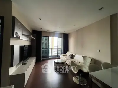 Modern living room with sleek furniture and large window offering city view