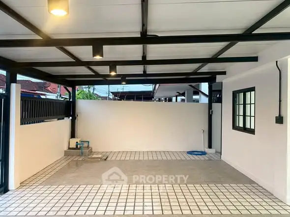 Spacious covered parking area with modern tiled flooring and lighting.