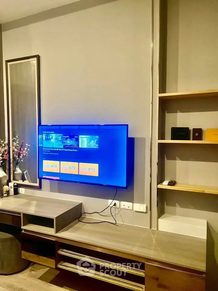 Modern living room with wall-mounted TV and stylish shelving