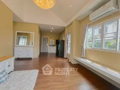 Spacious living room with elegant chandelier and large windows in modern home