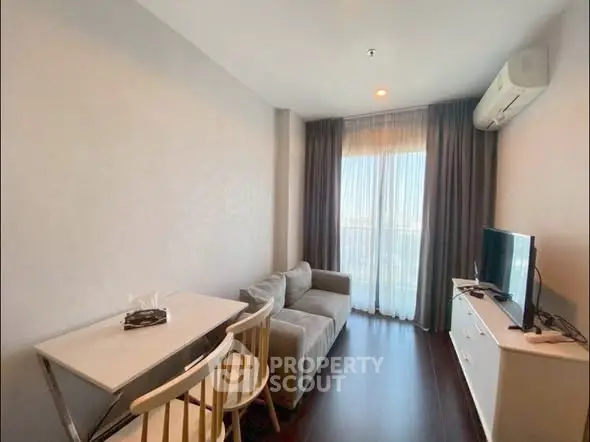 Modern living room with cozy sofa, TV, and dining area in a bright apartment.